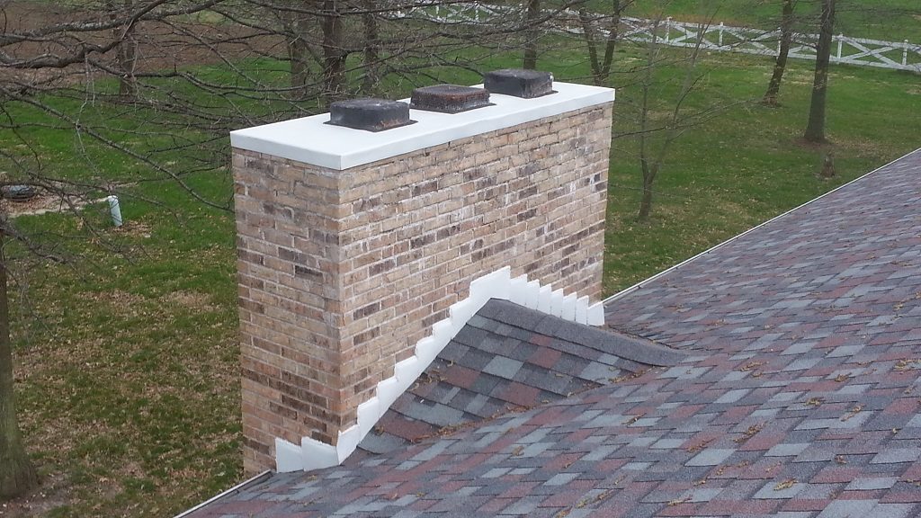 New chimney cap and step flashing on a shingle roof
