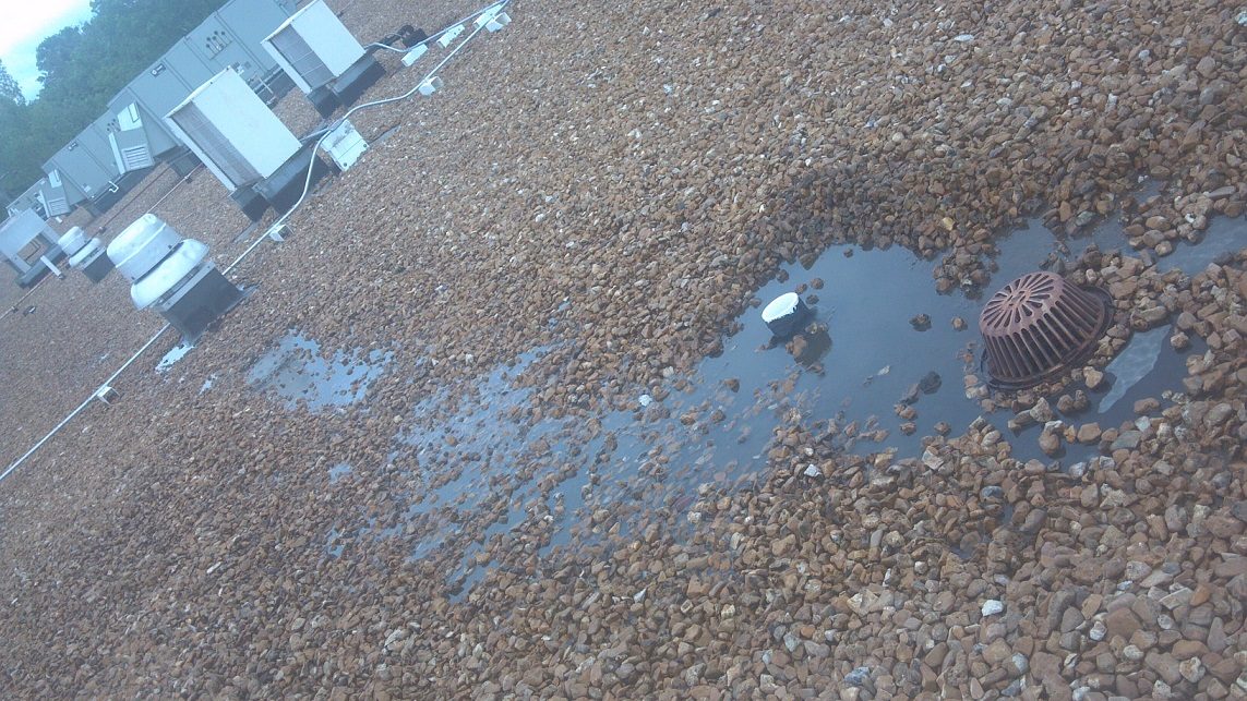 Water ponding around a drain on a gravel flat roof