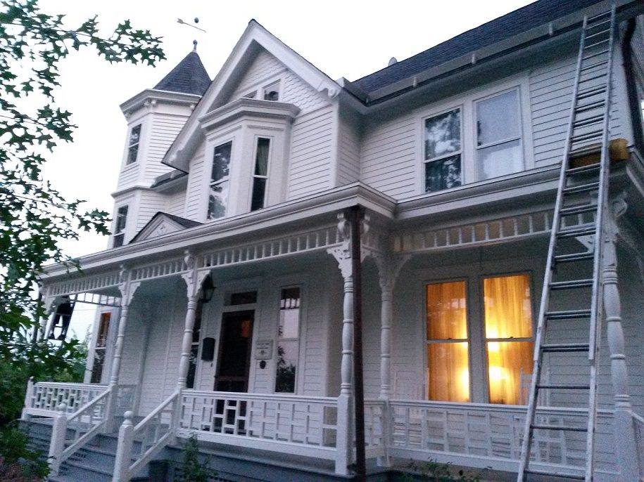 White Victorian home with a fresh roof and a ladder against the side, a Roof STL job
